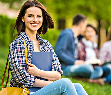 Studenten-Haftpflichtversicherung - Studentin sitzt im Park